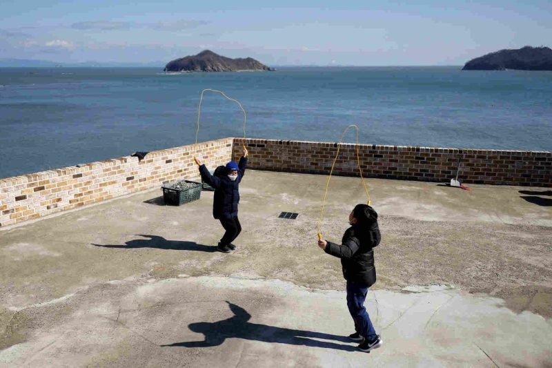 Chan hee dan Kim Si hu, 9 tahun, bermain lompat tali pada hari pertama sekolah di Pulau Nokdo, Korea Selatan.(@Reuters/Kim Hong Ji)