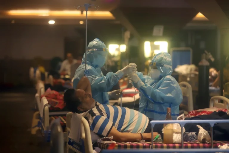 Petugas kesehatan merawat pasien covid 19 di rumah sakit darurat di New Delhi. (©AP)