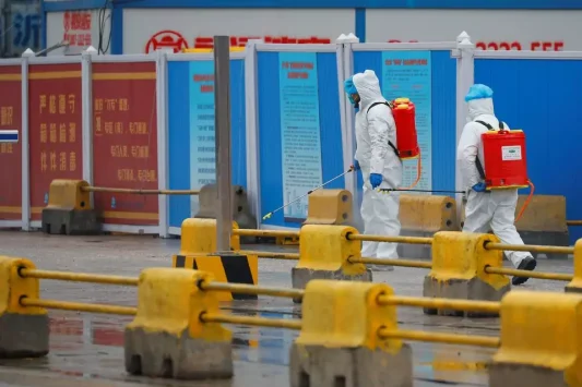 Petugas menyemprot disinfektan di pasar Baishazhou selama kunjungan tim WHO yang ditugaskan menyelidiki asal usul covid 19, di Wuhan, provinsi Hubei, Cina, 31 Januari 2021. Foto: Reuters
